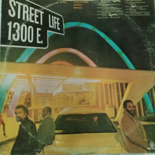 Album cover with a street sign and people by a car, featuring 'Street Life 1300 E.'